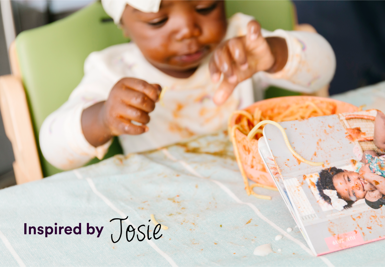 toddler enjoying spaghetti with a monthly mini