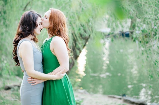 Couple kisses in a green backdrop