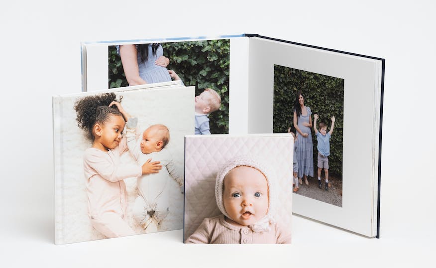 a collection of family photo books showing a baby on the cover and a family on premium pages