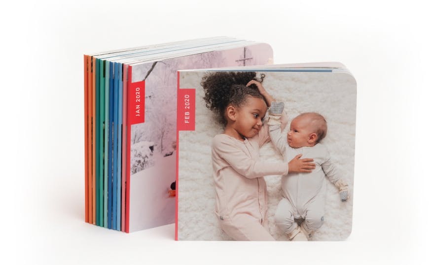 monthly photos book subscription book with two little girls on the cover and rainbow photo book spines