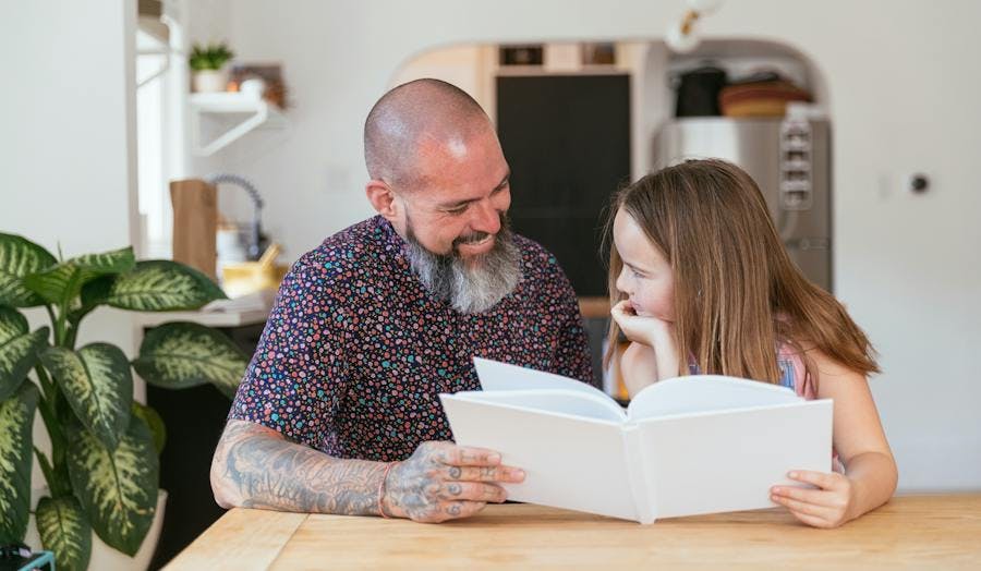 Father reading gift book from daughter
