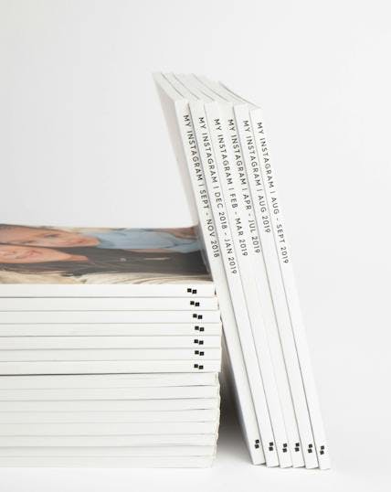 stack of Instagram photo books showing spines with custom names and date ranges
