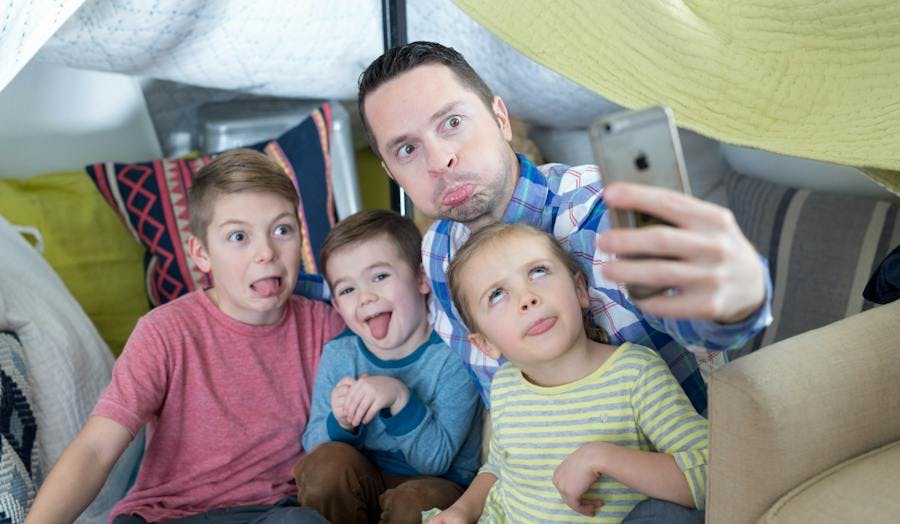 Dad and thee kids taking a silly selfie.